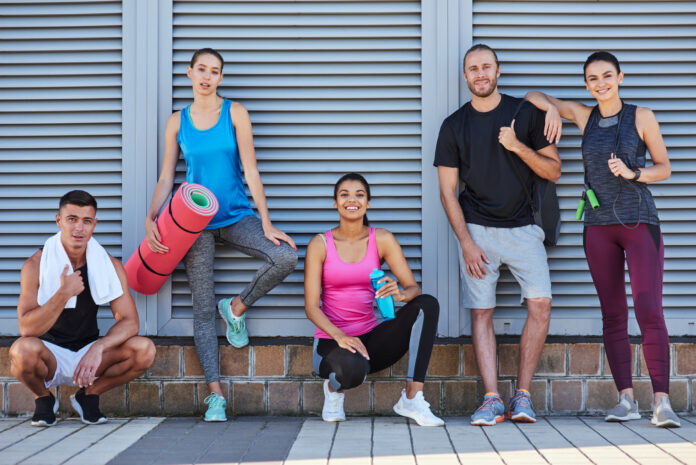 Happy mixed race youth holding sport equipment