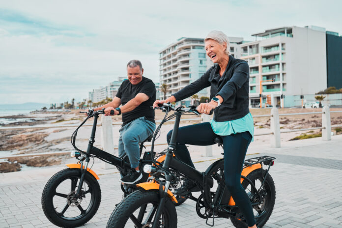 senior-couple-electric-bike-and-smile-by-the-beac-2023-11-27-05-06-16-utc